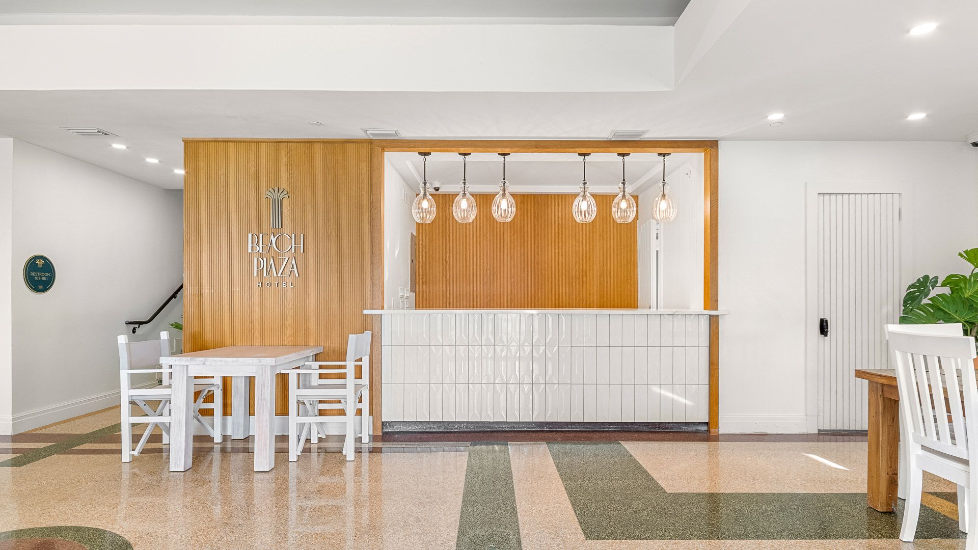 el lobby con su barra de madera y sillas blancas