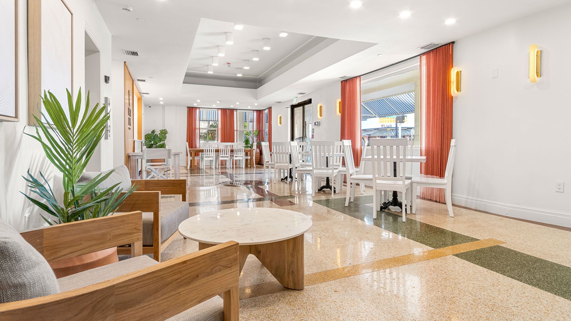el luminoso salón del lobby con suelo de terrazo y asientos de madera
