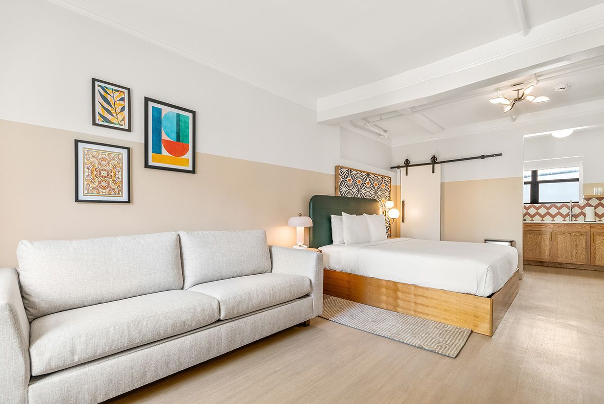 una suite con un sofá blanco y una cama king